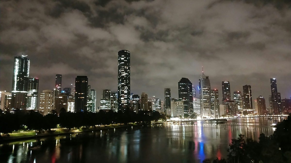 Brisbane's city skyline at night, reflected in the Brisbane River